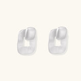 Pair of geometric sterling silver earrings with frosted square frames and glossy rounded studs on white background