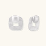 Pair of geometric sterling silver earrings with frosted square frames and glossy rounded studs on white background
