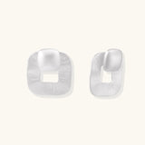 Pair of geometric sterling silver earrings with frosted square frames and glossy rounded studs on white background
