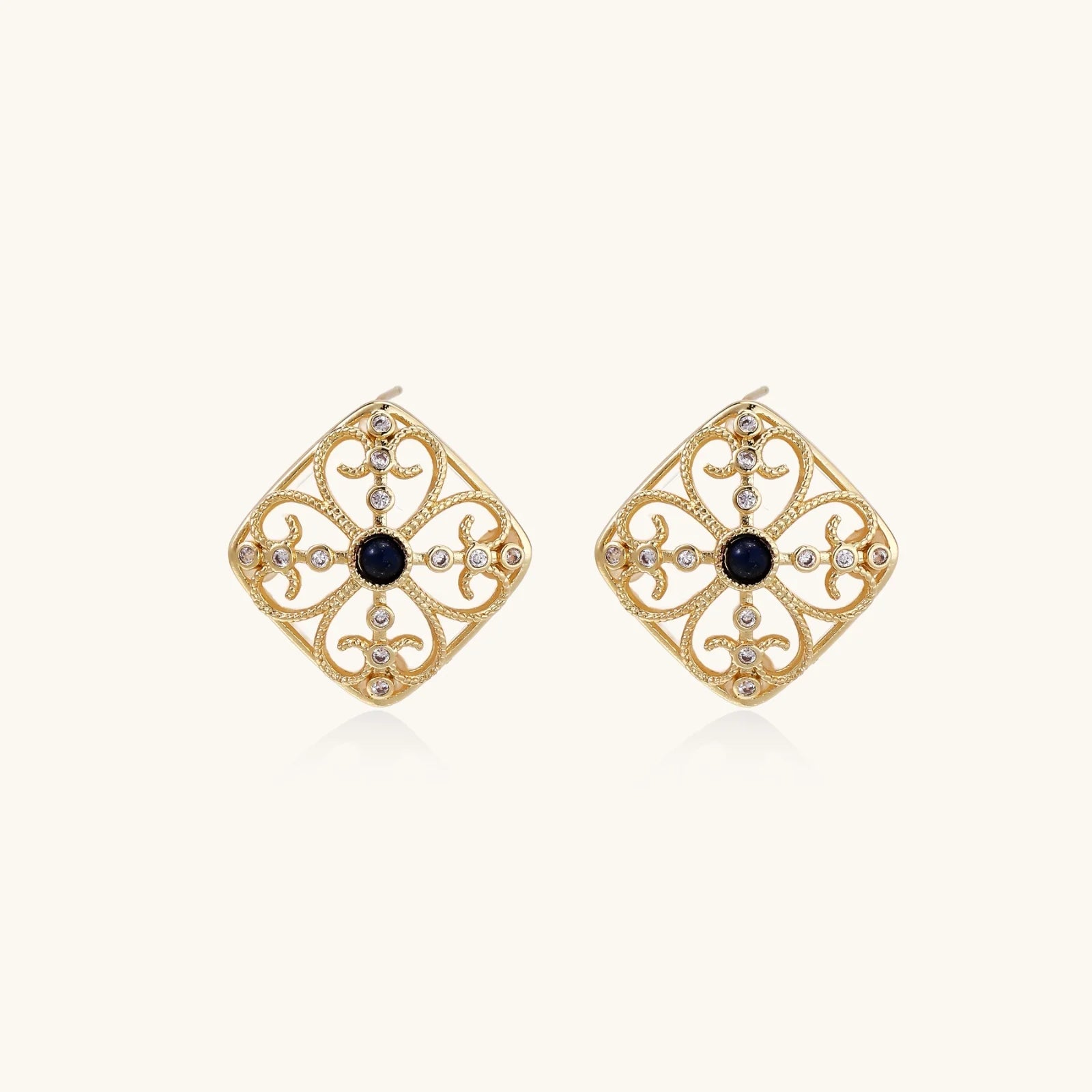 Gold filigree stud earrings with navy lapis lazuli center stone and mother-of-pearl accents in ornate quatrefoil design