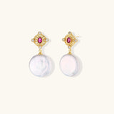 Gold baroque pearl earrings with pink gemstone studs and ornate detailing on cream background.