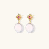Gold baroque pearl earrings with pink gemstone studs and ornate detailing on cream background.