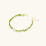 Delicate sterling silver bracelet with lime-green peridot gemstone chips and single freshwater pearl centerpiece