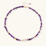 Beaded necklace with purple amethyst chips, freshwater pearls, and gold accents on white background.