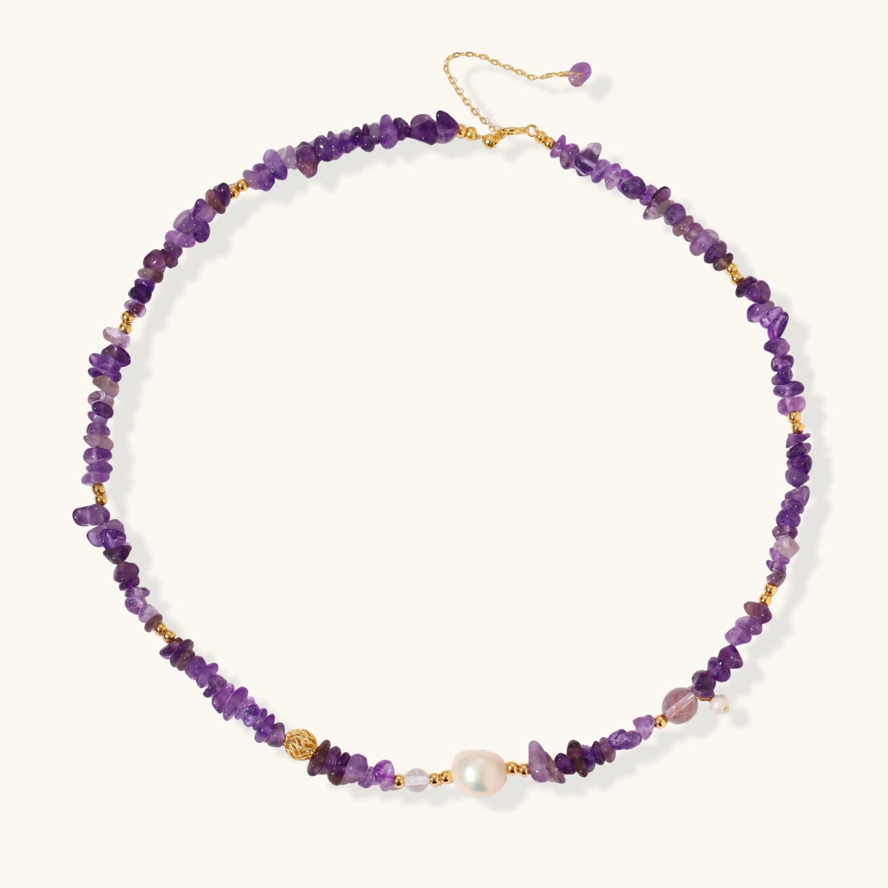 Beaded necklace with purple amethyst chips, freshwater pearls, and gold accents on white background.