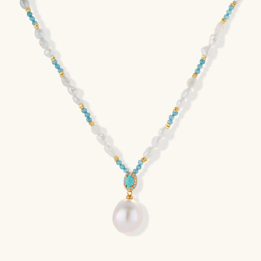 Beaded necklace with baroque pearls, turquoise stones, and gold accents featuring a large pearl pendant on white background.