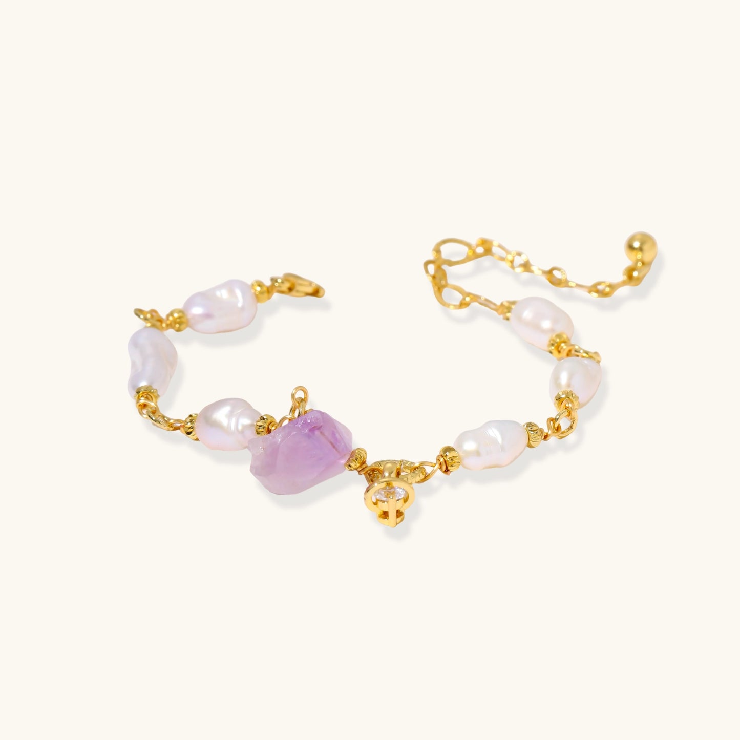 Gold-plated bracelet with lustrous baroque pearls and raw lavender amethyst centerpiece on white background.