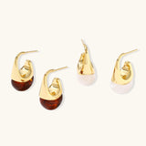 Modern drop earrings with curved gold-plated copper tops and amber resin bottoms creating an organic teardrop silhouette.
