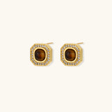 Gold-plated octagonal stud earrings with brown tiger's eye centers and cubic zirconia border on cream background.