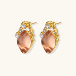 Gold-plated baroque stud earrings with coral-pink liuli stones and cubic zirconia crystals on white background.