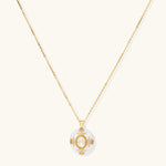 Gold-plated necklace with circular white enamel pendant featuring central zirconia stone and ornate decorative details
