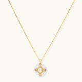 Gold-plated necklace with circular white enamel pendant featuring central zirconia stone and ornate decorative details