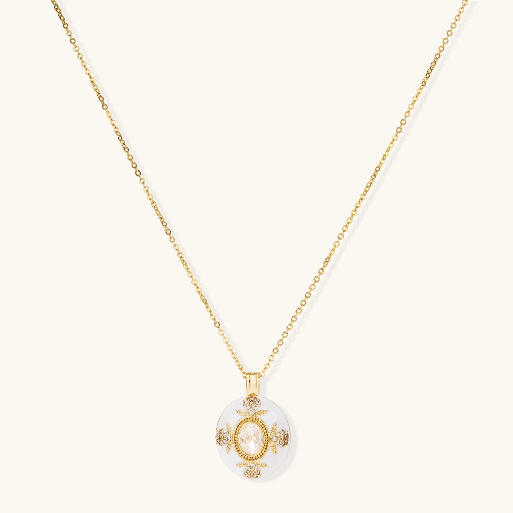 Gold-plated necklace with circular white enamel pendant featuring central zirconia stone and ornate decorative details