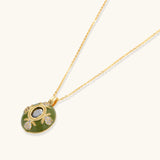 Gold-plated pendant necklace with green enamel background and oval olive cubic zirconia center stone with crystal accents.