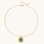 Gold-plated pendant necklace with green enamel background and oval olive cubic zirconia center stone with crystal accents.