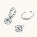 Sterling silver twisted hoop earrings with round moissanite stones in halo settings against neutral background.