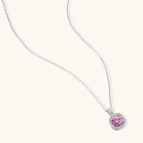 Sterling silver necklace with cushion-cut pink moissanite in diamond halo setting on white background