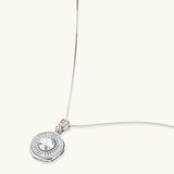 Sterling silver necklace with circular geometric pendant featuring central moissanite and radial baguette pattern.