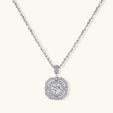 Sterling silver octagonal pendant necklace with brilliant moissanite center stone and halo setting on white background.