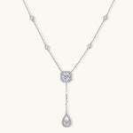 Sterling silver necklace with cushion-cut moissanite halo pendant and teardrop drop on white background