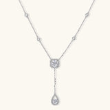 Sterling silver necklace with cushion-cut moissanite halo pendant and teardrop drop on white background
