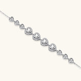Sterling silver bracelet with graduated heart-shaped links and sparkling moissanite stones in VVS1 clarity on white background.