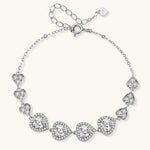 Sterling silver bracelet with graduated heart-shaped links and sparkling moissanite stones in VVS1 clarity on white background.