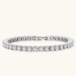 Sterling silver tennis bracelet with continuous row of brilliant moissanite stones and secure clasp closure on cream background.