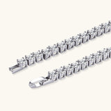 Sterling silver tennis bracelet with continuous row of brilliant moissanite stones and secure clasp closure on cream background.