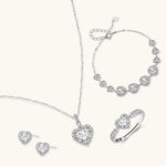 Complete jewelry set with heart-shaped sterling silver pieces featuring brilliant moissanite stones on white background.