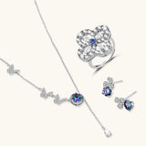 Sterling silver jewelry set with rainbow moissanite stones in clover and butterfly designs on cream background
