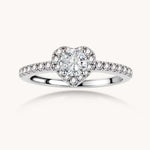 Heart-shaped halo ring with brilliant moissanite center stone surrounded by smaller crystals in sterling silver setting