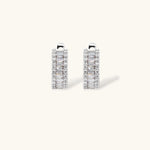 White gold plated necklace with vertical cubic zirconia pendant and matching hoop earrings on neutral background