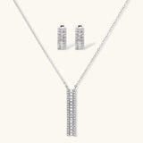 White gold plated necklace with vertical cubic zirconia pendant and matching hoop earrings on neutral background