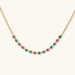 Gold-plated jewelry set with red, green, and blue cubic zirconia stones including necklace, bracelet, and drop earrings.