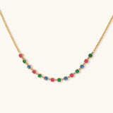 Gold-plated jewelry set with red, green, and blue cubic zirconia stones including necklace, bracelet, and drop earrings.