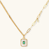 Gold-plated jewelry set with white enamel square pendants and emerald CZ stones on cream background.