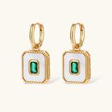 Gold-plated jewelry set with white enamel square pendants and emerald CZ stones on cream background.