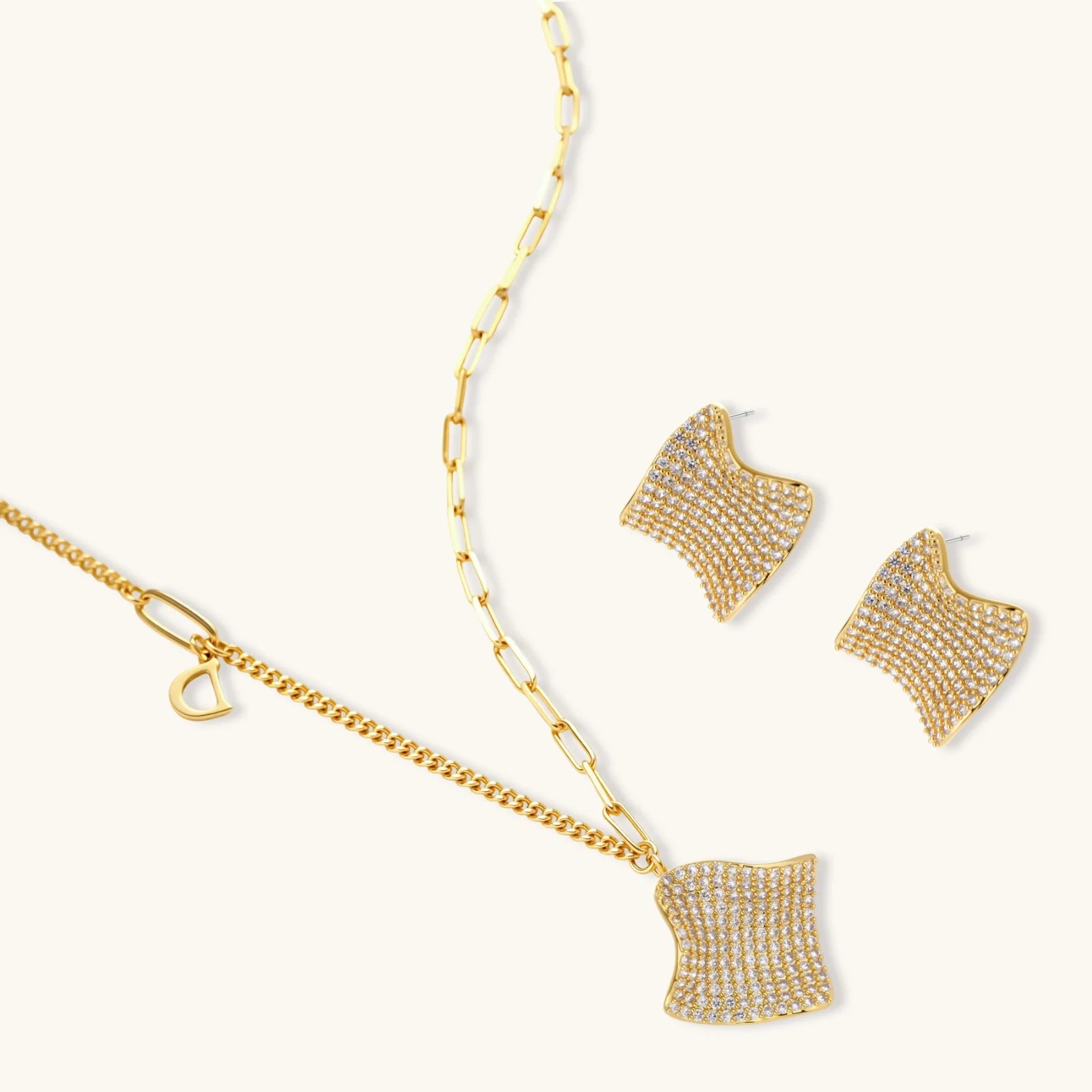 Gold-plated wavy jewelry set with crystal detailing featuring necklace with dual chains and matching textured earrings