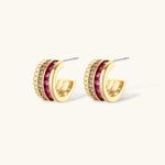 Three-piece jewelry set featuring 14K gold plated pieces with deep red cubic zirconia stones and clear crystals on cream background.