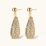 Gold-plated teardrop necklace and earrings covered in AAA cubic zirconia crystals on cream background.