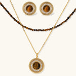 Gold-plated circular pendant necklace and matching earrings with natural stone centers and ornate rope detailing
