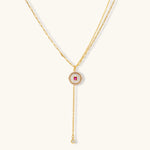 Gold-plated circular medallion necklace set with white enamel base and pink cubic zirconia accent stones