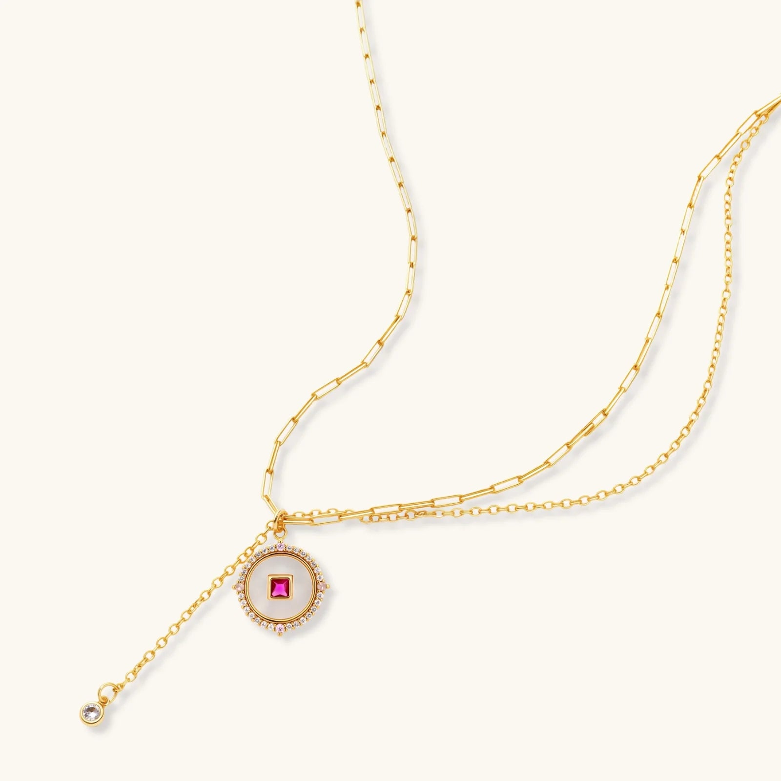 Gold-plated circular medallion necklace set with white enamel base and pink cubic zirconia accent stones