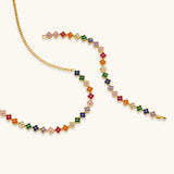 Colorful four-leaf clover jewelry set with rainbow cubic zirconia stones in gold-plated setting on white background