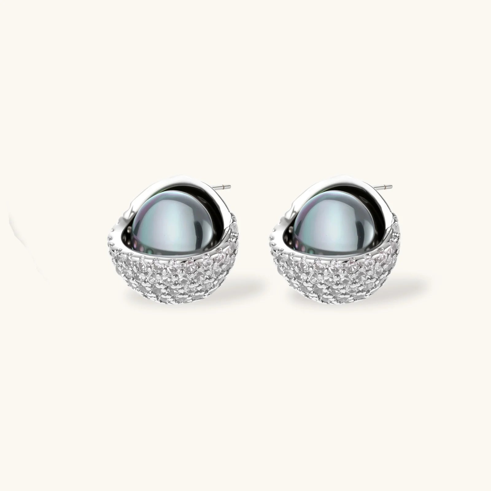 Elegant spherical pendant necklace and earrings set featuring crystal-pavé bottom half in gold or silver finish on white background.
