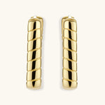Chunky segmented gold-plated huggie hoop earrings with bamboo-inspired geometric design on white background.
