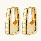 Chunky segmented gold-plated huggie hoop earrings with bamboo-inspired geometric design on white background.