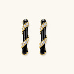 Small gold-plated hoop earrings with black enamel stripes and cubic zirconia crystals on white background.