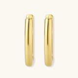Polished gold-plated sterling silver hoop earrings with hinged closure mechanism on white background.